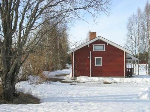 a red barn in the snow next to a tree at Holiday Home Hilla by Interhome in Jokijärvi