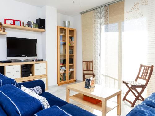 ein Wohnzimmer mit einem blauen Sofa und einem TV in der Unterkunft Apartment Edif- Museo 2ºk by Interhome in Torre de Benagalbón