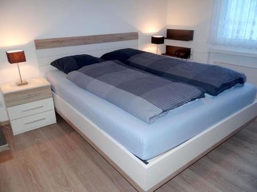 sypialnia z dużym łóżkiem z niebieską i szarą pościelą w obiekcie Apartment Birkenstrasse 56 by Interhome w mieście Engelberg