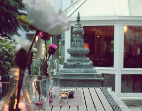 a table with vases and flowers on top of it at Princess No3 Self Check-In Plochingen bei Stuttgart in Plochingen