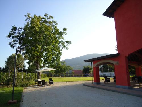 a pavilion with chairs and an umbrella next to a building at Agrituirsmo Masseria Campierti in Falciano del Massico