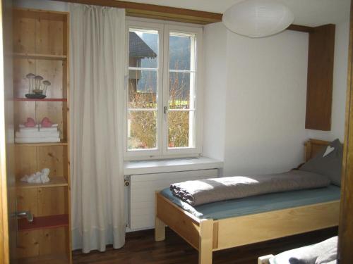 1 dormitorio con cama y ventana en Apartment Villa Alpenblick Wolfenschiessen by Interhome, en Wolfenschiessen