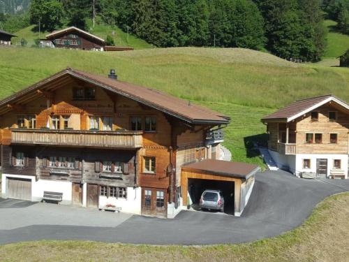 a large house with a car parked in front of it at Apartment Chalet Wäschhüsi by Interhome in Adelboden
