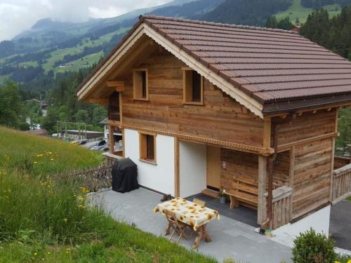a wooden house with a table in front of it at Apartment Chalet Wäschhüsi by Interhome in Adelboden