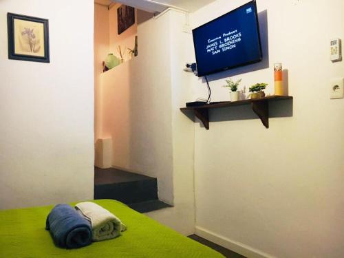 a room with a bed and a tv on a wall at Destino26 Hostel in Montevideo