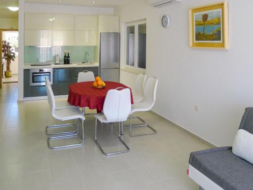 a kitchen with a table with white chairs and a red table cloth at Holiday Home Villa Zlatan by Interhome in Stari Grad