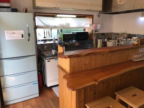 eine Küche mit einer Theke und einem Kühlschrank in der Unterkunft Guesthouse SORA in Minamiizu