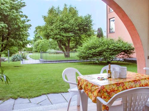 a table and chairs on a patio with a yard at Apartment Sabrina by Interhome in Ascona