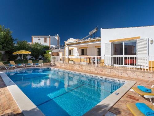 a villa with a swimming pool in front of a house at Villa Villa Natura by Interhome in Guia