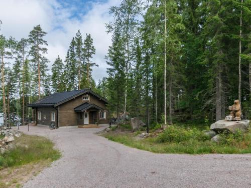 a cabin in the woods with a gravel road at Holiday Home Apilan rauha by Interhome in Kerttee