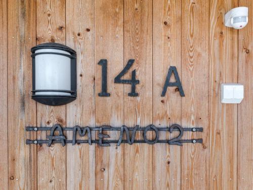 a light on a wooden wall with a sign on it at Holiday Home Ameno 2 by Interhome in Jämsä