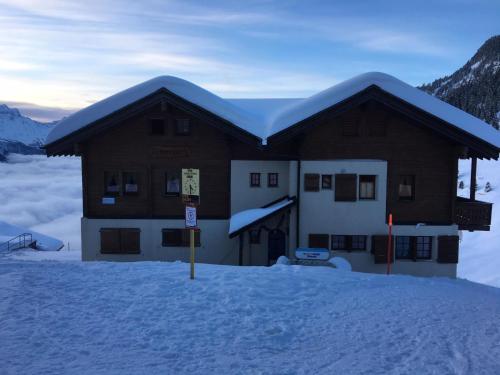 a building with a snow covered roof in the snow at Apartment Almenrausch Parterre by Interhome in Riederalp