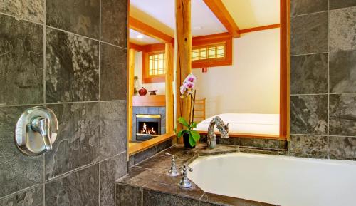 a bathroom with a tub and a fireplace at Inn at Depot Hill in Capitola