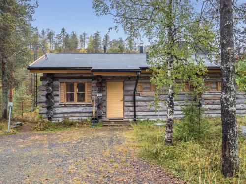 una cabaña de madera con una puerta amarilla en el bosque en Holiday Home Ruska-ruka 8-3 by Interhome, en Ruka