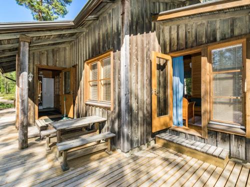 uma cabina de madeira com um banco num deque em Holiday Home Lauhanlinna by Interhome em Isojoki
