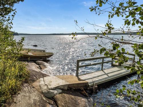 a dock with a boat on a lake at Holiday Home Huotarin mökki by Interhome in Tervajärvi