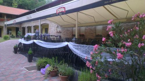 a patio with potted plants and a building with a canopy at Rooms Villa Iva in Ilok