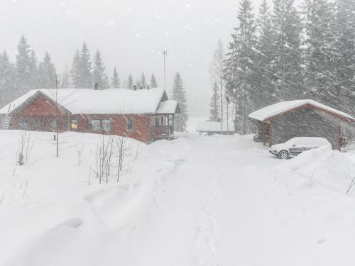 uma casa coberta de neve com um carro estacionado na frente em Holiday Home Virransivu by Interhome em Kaipiainen