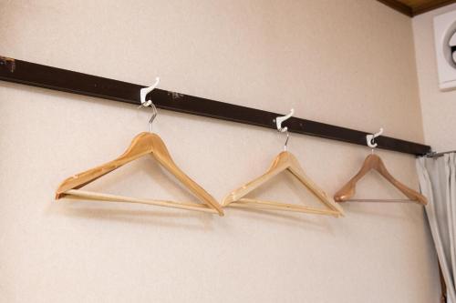 three wooden hangers are hanging on a wall at Yufuin Yukari-an Megumi no Sato in Yufuin