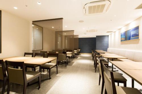 a dining room with wooden tables and chairs at JR Kyushu Station Hotel Kokura in Kitakyushu