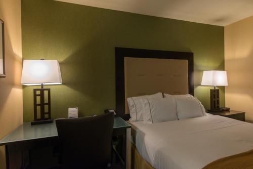 a bedroom with a bed and a desk with two lamps at Holiday Inn Express Portland East - Columbia Gorge, an IHG Hotel in Troutdale