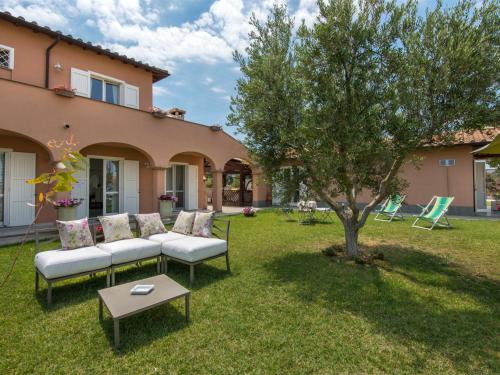 a backyard with a couch and a tree at Villa Marina Velca by Interhome in Tarquinia