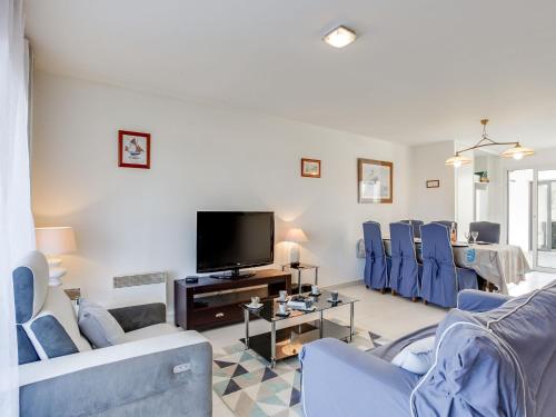 Il comprend un salon doté de fauteuils bleus et d'une télévision à écran plat. dans l'établissement Holiday Home Ty Castero by Interhome, à Quiberon