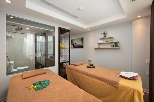 two beds in a room with a shower at 22Land 71 Hang Bong Hotel in Hanoi