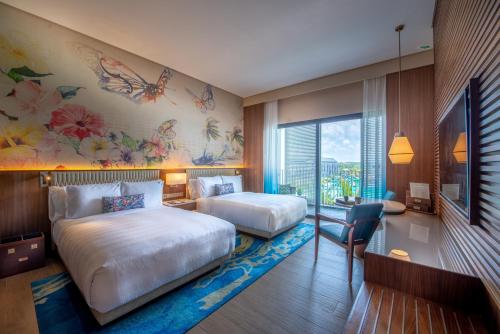 a hotel room with two beds and a large window at Hard Rock Hotel Desaru Coast in Desaru