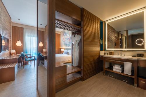 デサルにあるHard Rock Hotel Desaru Coastのベッドとバスルーム付きのホテルルームです。