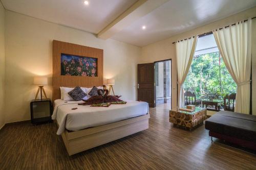 1 dormitorio con 1 cama grande y sala de estar en Dewangga Ubud en Ubud