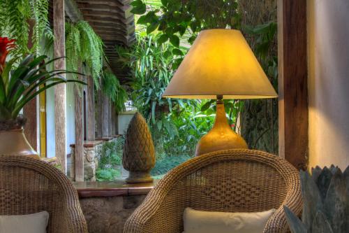a lamp sitting on a table next to two chairs at Pousada do Ouro in Paraty