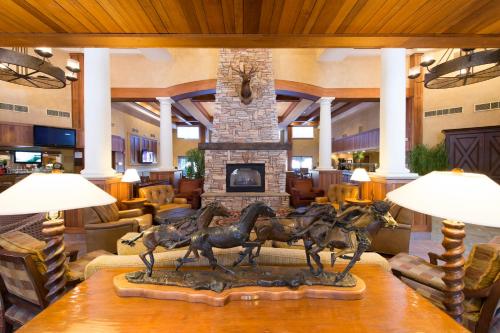 a bronze statue of horses in front of a fireplace at MCM Elegante Lodge & Resorts in Ruidoso