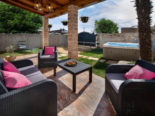 a patio with couches and a table and a pool at Holiday Home Villa Aurora in Loborika