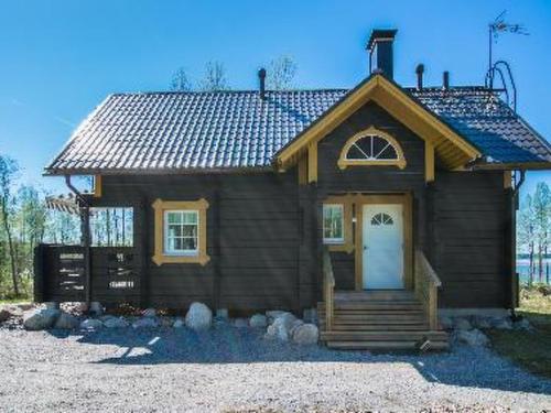 a small house with a white door and a porch at Holiday Home Runopuro by Interhome in Kerkonjoensuu