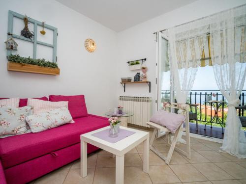 salon z różową kanapą i stołem w obiekcie Apartment Moira-2 by Interhome w mieście Ika