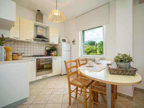 kuchnia ze stołem i krzesłami oraz oknem w obiekcie Apartment Moira-2 by Interhome w mieście Ika