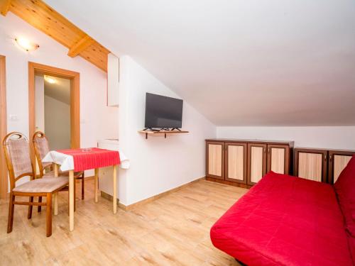 ein Wohnzimmer mit einem roten Sofa und einem Tisch in der Unterkunft Apartment Hilde Red-11 by Interhome in Medulin