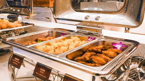 a buffet with many different types of food on a stove at Paco Hotel Tiyuxilu Metro Guangzhou-Free Shuttle Bus during Canton Fair&5 Min walk to Canton Fair Buyer Registration Store in Guangzhou