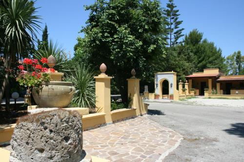 a fence with a large vase of flowers on a street at Hotel Villa Rita in Paestum