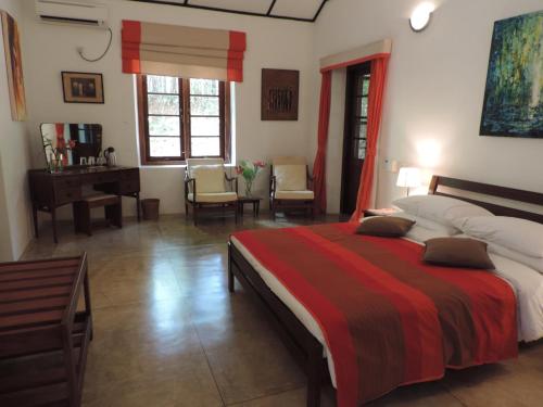 a bedroom with a bed and a desk and a piano at Rosyth Estate House in Pinnawala