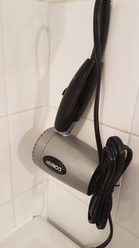 a hair dryer is hanging on a wall at 1-Bedroom Cozy Sweet #22 by Amazing Property Rentals in Gatineau