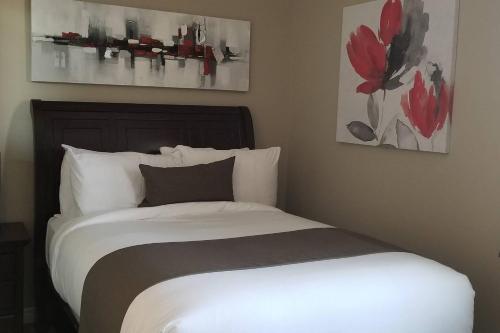 um quarto com uma cama e duas pinturas na parede em 1-Bedroom Cozy Sweet #22 by Amazing Property Rentals em Gatineau