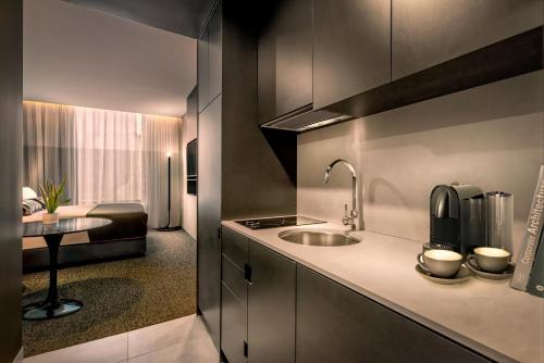 a kitchen with a sink and a table in a room at Veriu Green Square in Sydney