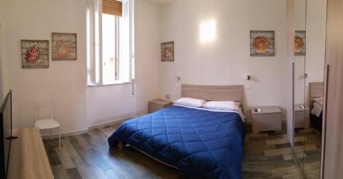 a bedroom with a blue bed and a window at A Casa di Asia in Grosseto