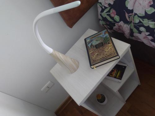 a white end table with a picture and a charger at En el centro y hermosa vista! Con cochera in Trujillo