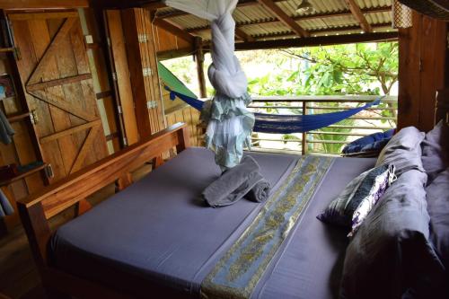 a bed in a room with a hammock at Beach House Cambodia in Koh Rong Sanloem