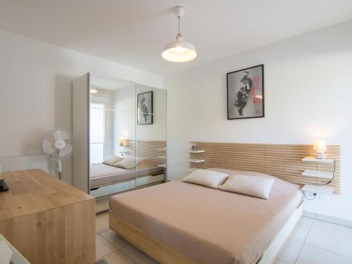 a bedroom with a bed and a large mirror at Apartment Royal Rivage-2 by Interhome in Carqueiranne