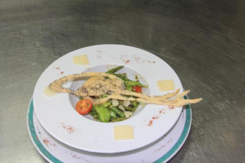 a plate of food with vegetables on a table at Auberge Du Cheval Blanc in Beaumont-Pied-de-Boeuf