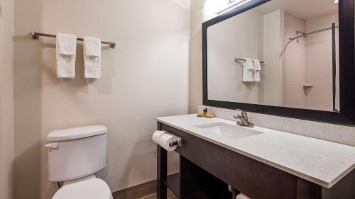 a bathroom with a toilet and a sink with a mirror at Best Western Plus Ardmore Inn & Suites in Ardmore